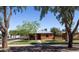 Quaint brick home surrounded by mature trees and a well-maintained lawn at 1546 W Culver St, Phoenix, AZ 85007