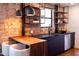 Well-lit kitchen area with dark cabinets, stainless steel appliances and exposed brick at 1546 W Culver St, Phoenix, AZ 85007