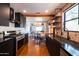 Modern kitchen featuring stainless steel appliances, dark cabinets, and brick accent wall, open to the dining area at 1546 W Culver St, Phoenix, AZ 85007