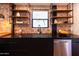 Close-up of a kitchen sink with dark cabinets, stainless steel appliances and exposed brick at 1546 W Culver St, Phoenix, AZ 85007