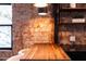 Close-up of a kitchen with breakfast bar, exposed brick and wood shelving at 1546 W Culver St, Phoenix, AZ 85007