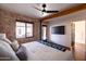 Spacious primary bedroom offering brick accent walls, a ceiling fan, backyard access, and a modern entertainment center at 1546 W Culver St, Phoenix, AZ 85007