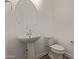 Powder room with white pedestal sink, round mirror, and modern fixtures, providing convenience at 1564 N Pueblo Dr, Apache Junction, AZ 85120