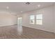 Open living room featuring wood-look tile and three large windows with sliding patio door at 1564 N Pueblo Dr, Apache Junction, AZ 85120