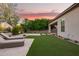Expansive backyard featuring manicured landscaping, artificial grass, and lounge chairs at 18025 N 65Th Pl, Phoenix, AZ 85054