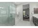 Elegant bathroom featuring marble tile, a glass-enclosed shower, soaking tub, and dual vanities at 18025 N 65Th Pl, Phoenix, AZ 85054