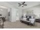 Cozy bedroom featuring a comfortable bed, bench, ceiling fan, and doorway to a luxurious bathroom at 18025 N 65Th Pl, Phoenix, AZ 85054
