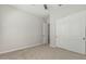 Empty bedroom with carpet floors, ceiling fan, and closet with bi-fold doors at 18025 N 65Th Pl, Phoenix, AZ 85054