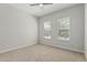 Empty bedroom with carpet floors, ceiling fan, and two bright windows overlooking neighborhood at 18025 N 65Th Pl, Phoenix, AZ 85054