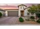 Charming exterior elevation showcases a well-manicured yard, brick driveway, and neutral color palette creating a welcoming curb appeal at 18025 N 65Th Pl, Phoenix, AZ 85054