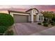 Charming exterior elevation showcases a well-manicured yard, brick driveway, and neutral color palette creating a welcoming curb appeal at 18025 N 65Th Pl, Phoenix, AZ 85054