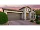 Charming exterior elevation showcases a well-manicured yard, brick driveway, and neutral color palette creating a welcoming curb appeal at 18025 N 65Th Pl, Phoenix, AZ 85054
