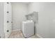 Bright laundry room with full-size white washer and dryer, overhead shelf, and tile flooring at 18025 N 65Th Pl, Phoenix, AZ 85054