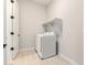 Bright laundry room with tiled floors, washer and dryer, and a white shelf above at 18025 N 65Th Pl, Phoenix, AZ 85054