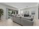 Spacious living room featuring a large sofa, stylish decor, and sliding glass doors leading to the backyard at 18025 N 65Th Pl, Phoenix, AZ 85054
