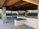 Outdoor lounge with covered seating, grilling area, and views of the surrounding community at 18025 N 65Th Pl, Phoenix, AZ 85054