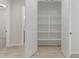 Bright pantry featuring white shelves and tile flooring with door to a bedroom in the distance at 18025 N 65Th Pl, Phoenix, AZ 85054