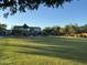 Community playground with covered play structure and open grassy area for recreation at 18025 N 65Th Pl, Phoenix, AZ 85054