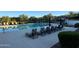 Community pool area featuring lounge chairs, umbrellas, and lush landscaping at 18025 N 65Th Pl, Phoenix, AZ 85054