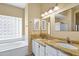 Bright bathroom featuring dual sinks, granite counters, and a soaking tub at 1975 E Chilton Dr, Tempe, AZ 85283