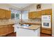 Contemporary kitchen with wooden cabinets, an island cooktop, and stylish backsplash at 1975 E Chilton Dr, Tempe, AZ 85283