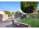 Relaxing backyard featuring a pool, patio area with chairs, lush lawn, and mature shade trees at 1975 E Chilton Dr, Tempe, AZ 85283