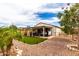 Expansive backyard featuring a covered patio with a hot tub, outdoor seating, and lush artificial turf at 19858 W San Juan Ave, Litchfield Park, AZ 85340