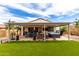 Spacious backyard featuring a covered patio with a hot tub, outdoor seating, and well-maintained landscaping at 19858 W San Juan Ave, Litchfield Park, AZ 85340