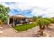 Inviting covered backyard patio featuring an outdoor kitchen, heaters, and well-manicured desert landscaping at 19858 W San Juan Ave, Litchfield Park, AZ 85340