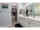 Bright bathroom and walk-in closet with tile floors, dual sinks, and white cabinets at 19858 W San Juan Ave, Litchfield Park, AZ 85340