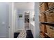 Bright bathroom and walk-in closet with tile floors, dual sinks, and storage baskets on shelves at 19858 W San Juan Ave, Litchfield Park, AZ 85340
