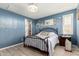Bedroom with light hardwood floors and a large iron bed and bright blue walls at 19858 W San Juan Ave, Litchfield Park, AZ 85340
