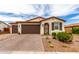 Charming single-story home featuring a three-car garage, desert landscaping, and a decorative front door at 19858 W San Juan Ave, Litchfield Park, AZ 85340