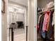 Hallway closet with coats and other items hanging up and office space visible through doorway at 19858 W San Juan Ave, Litchfield Park, AZ 85340