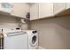 Bright laundry room with a large capacity washer and dryer and lots of shelf space for storage at 19858 W San Juan Ave, Litchfield Park, AZ 85340