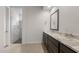 Bathroom featuring dual sinks, granite counters, dark cabinetry, and walk-in shower at 22523 E Orchard Ln, Queen Creek, AZ 85142