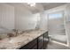 Bright primary bathroom features double sinks with granite counters and tub-shower combo with neutral paint at 22523 E Orchard Ln, Queen Creek, AZ 85142