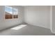 Bright bedroom features a large window allowing lots of natural light with neutral carpeting and a white door at 22523 E Orchard Ln, Queen Creek, AZ 85142