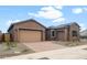 Beautiful home showcasing a well-maintained front yard, a two-car garage, and a stone accent exterior at 22523 E Orchard Ln, Queen Creek, AZ 85142