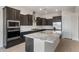 Gorgeous kitchen featuring stainless steel appliances, dark cabinets, and a large island at 22523 E Orchard Ln, Queen Creek, AZ 85142