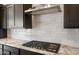 Modern kitchen features stainless steel hood, cooktop, granite counters, and dark cabinets at 22523 E Orchard Ln, Queen Creek, AZ 85142
