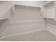 Bright walk-in closet features white walls, carpet flooring and built in shelving for optimal storage and organization at 22523 E Orchard Ln, Queen Creek, AZ 85142