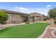 Well-maintained backyard featuring artificial turf, desert landscaping, and a covered patio at 23077 S 214Th St, Queen Creek, AZ 85142
