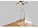 An empty bedroom with wooden floor, ceiling fan, and a closet at 23077 S 214Th St, Queen Creek, AZ 85142