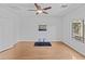 Bright bedroom features a ceiling fan, light hardwood floors, and a sunny window at 23077 S 214Th St, Queen Creek, AZ 85142