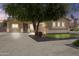Single story home with a well-manicured front yard and desert landscaping and mature shade tree at 23077 S 214Th St, Queen Creek, AZ 85142