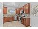 Well-lit kitchen features stainless steel appliances, dark wood cabinets and marbled granite countertops at 23077 S 214Th St, Queen Creek, AZ 85142