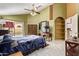 Bright bedroom features tile floor, ceiling fan, and sliding glass doors to backyard with pool at 3505 E South Fork Dr, Phoenix, AZ 85044