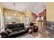 Spacious living room with a fireplace, leather furniture, stylish decor, and views into the kitchen area at 3505 E South Fork Dr, Phoenix, AZ 85044