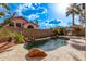 Resort-style backyard with pool, spa, rock waterfall, palm trees, and barbecue at 3505 E South Fork Dr, Phoenix, AZ 85044